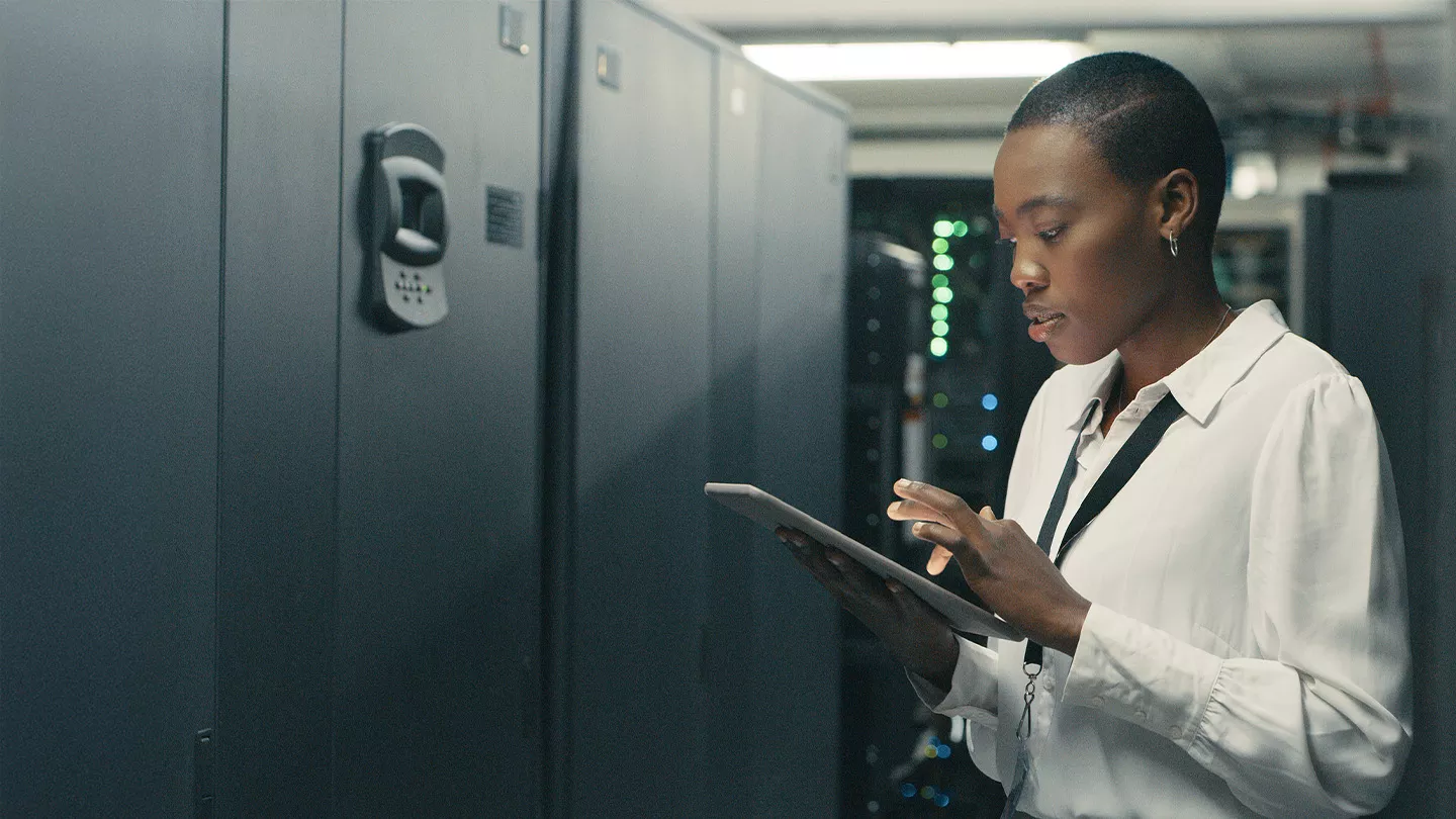 Femme dans une salle serveur avec une tablette