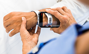 Nurse scanning a patients armband with mobile nurse call device