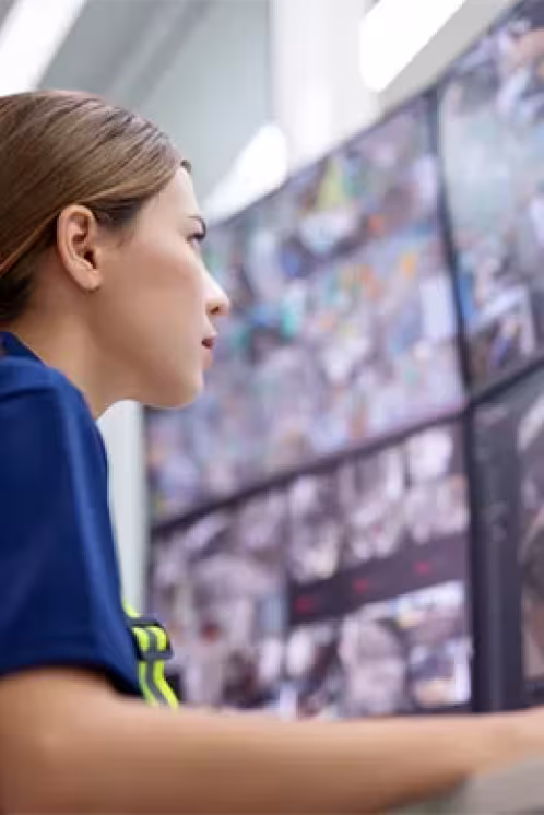 Femme en mission de surveillance devant des écrans