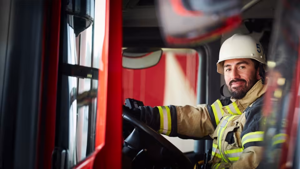 Homme pompier au volant de son camion