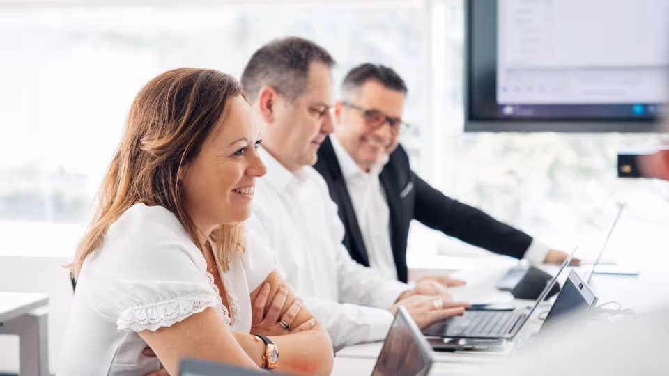 Femme qui sourit avec ses collègues pendant la formation DATI Connect