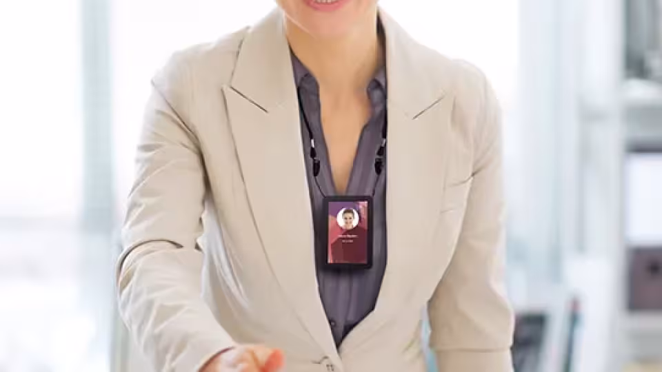 Femme souriante équipée d'un porte badge.